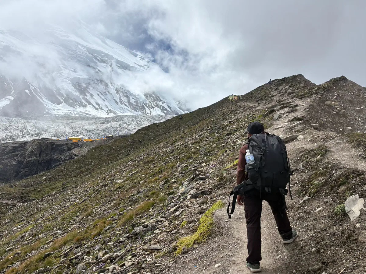 氷河沿いの登山道を歩く登山者